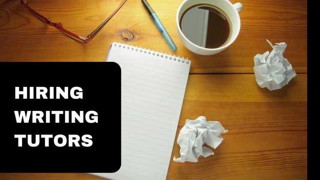 On a wooden table, there is a blank lined notebook, a pen, two crumpled up balls of paper, a black coffee, and a pair of glasses. On the left side, there is a black panel with white text that says "Hiring Writing Tutors." 